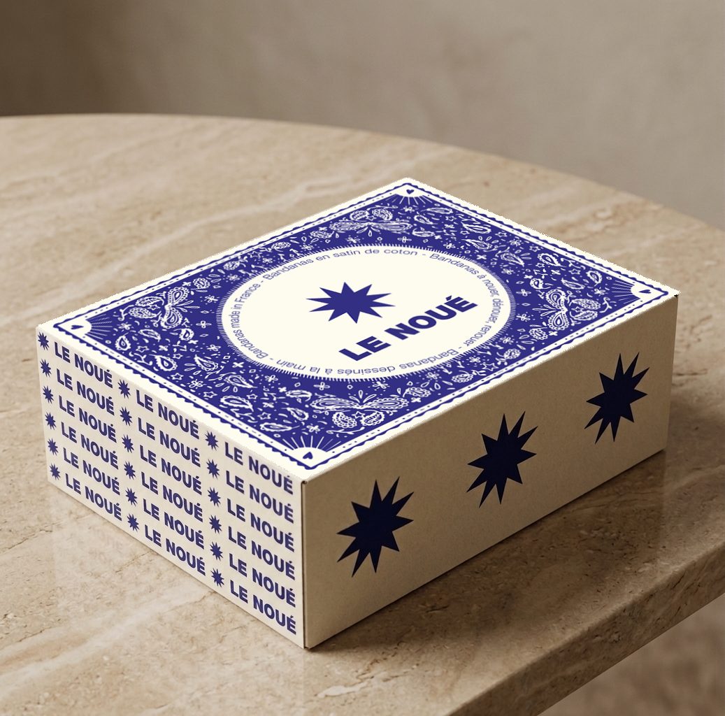 Boîte Le Noué en bleu et écru, motif cachemire et étoiles, sur une table en travertin