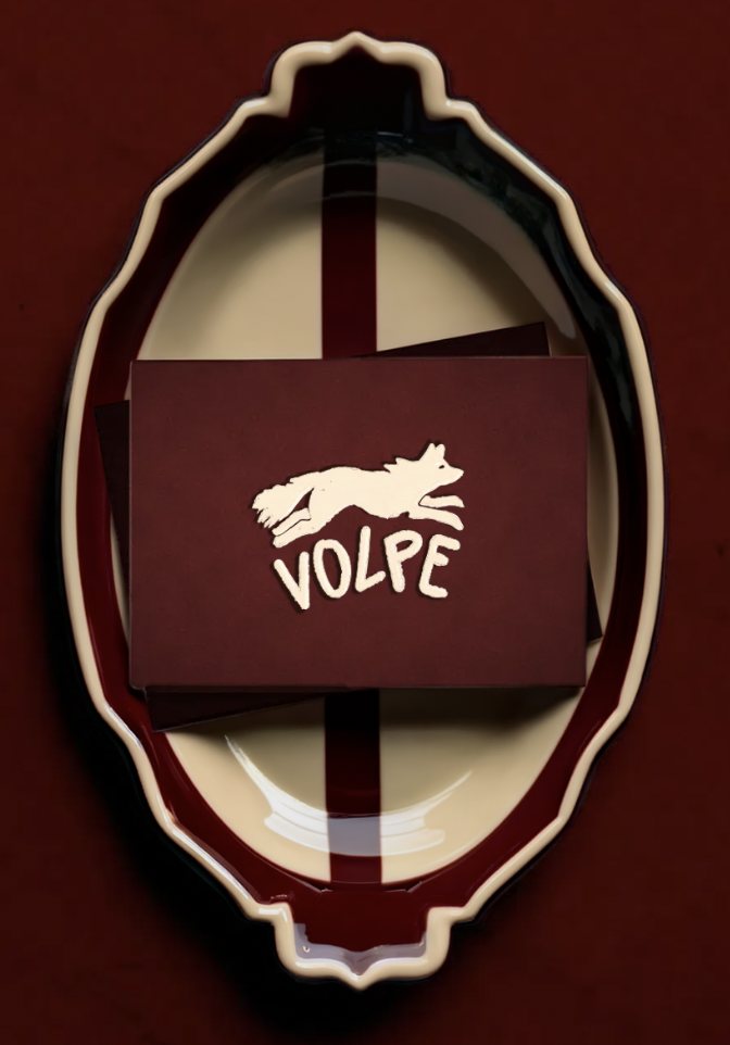 Cartes Volpe bordeaux au logo renard écru, posées dans un plat ovale crème et bordeaux